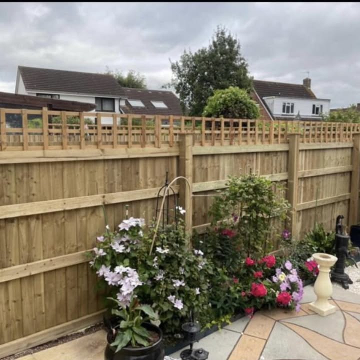 Closeboard fencing with a trellis topper above a planted patio