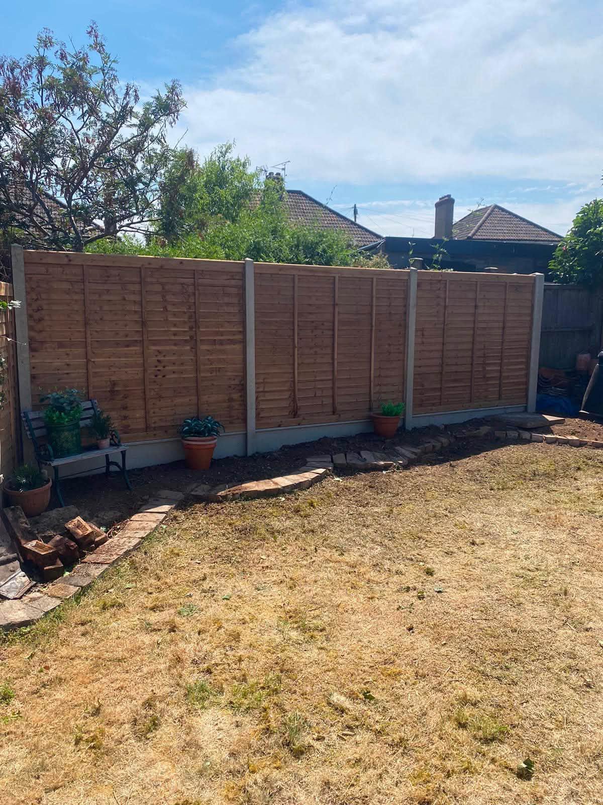 After: the hedge gone and a new run of lap panels on concrete posts