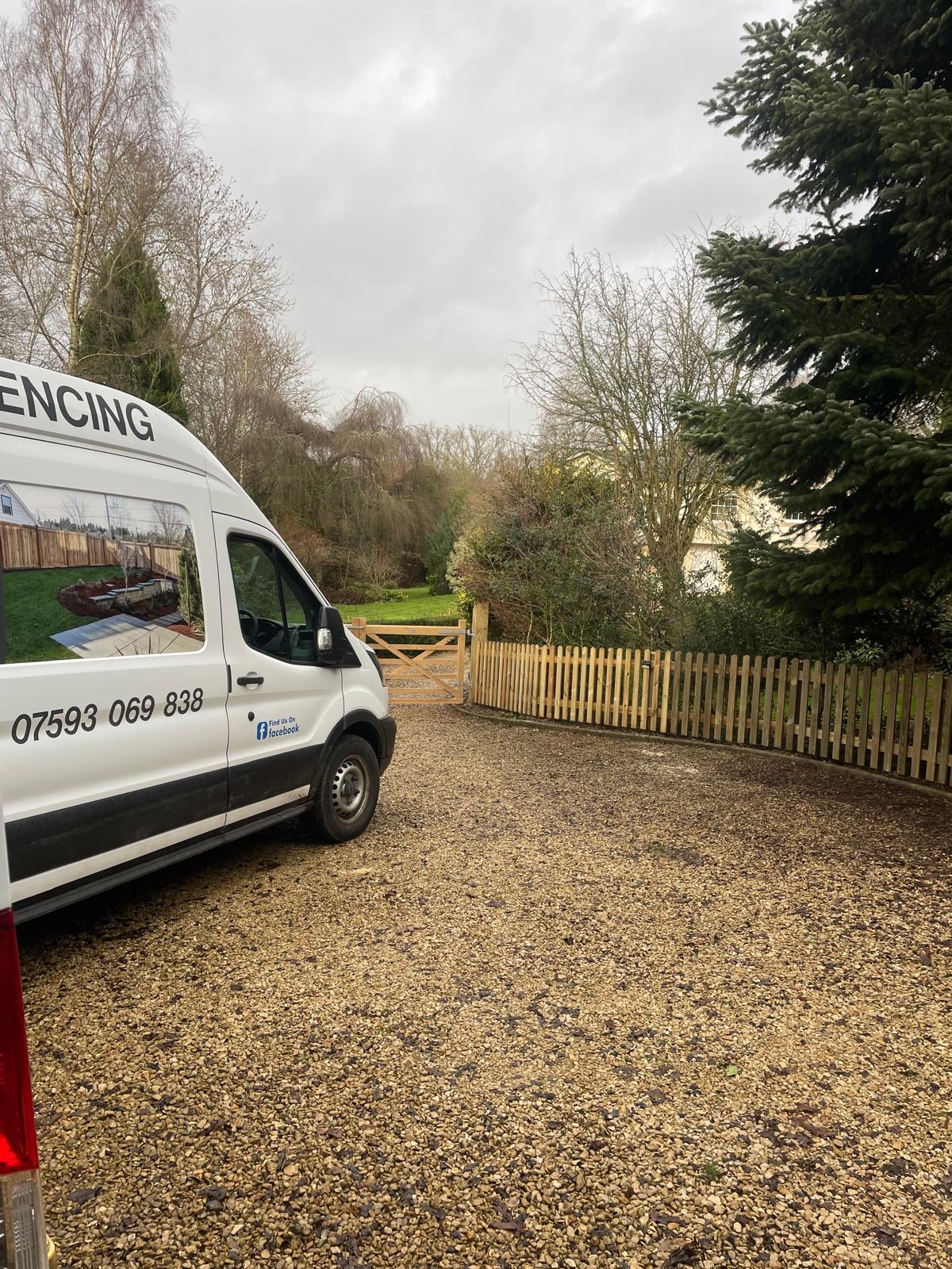 The Whitmores Fencing van on a gravel drive beside new picket fencing